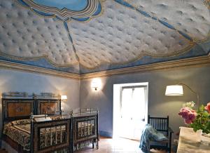 a bedroom with a ceiling with a bed and a window at Dimora Sessanio in Santo Stefano di Sessanio