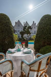 a dining room table with chairs and flowers on it at Exclusive Suites The Secret Garden in Bruges