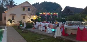 una mesa preparada para una fiesta frente a una casa en Rocks villa homestay, en Galu