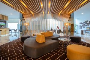 a lobby with a couch and chairs and tables at HF Fenix Urban in Lisbon