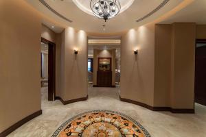 a hallway with a rug on the floor and a chandelier at Warwick Al Khobar in Al Khobar