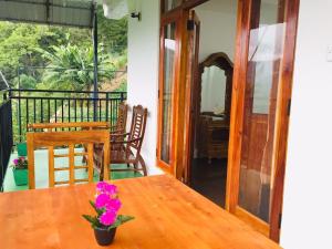 un tavolo in legno con un vaso di fiori sul balcone di Ella Elegance View a Ella
