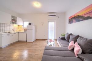 a living room with a couch and a kitchen at Apartments Braut Krk in Krk
