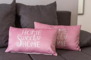 a pink pillow with the words home sweet home on it at Apartments Braut Krk in Krk