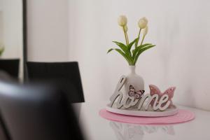 a vase with flowers in it on a table at Apartments Braut Krk in Krk