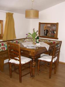 a wooden table with two chairs and a bottle of wine at Kaiserhof in Alpbach +30 photos