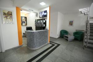 um átrio com uma sala de espera com cadeiras verdes em Hotel Korzo em Bitola