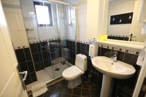 a bathroom with a toilet and a sink and a shower at Hotel Korzo in Bitola