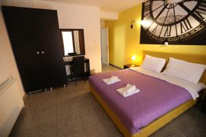 a bedroom with a large clock on the wall at Hotel Korzo in Bitola