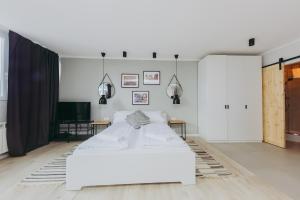 1 dormitorio blanco con 1 cama blanca y TV en ShortStayPoland Pereca (B68), en Varsovia