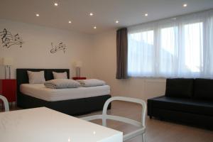 a bedroom with a bed and a chair and a couch at Broadway Center Rooftop View Apartment in Budapest