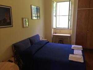 a bedroom with a blue bed and a window at Queen bedroom in Terracina