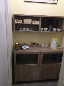 a wooden cabinet in a room with dishes on it at Queen bedroom in Terracina