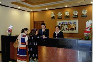 Faletti's Hotel Lahore في لاهور: مجموعة من الناس تقف في مكتب الاستقبال