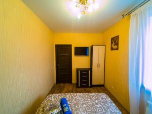 a bedroom with yellow walls and a bed and a television at Kvartirkoff na Petra Kalnyshevsky 7, 26 floor in Kyiv