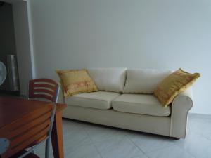un divano bianco con cuscini in soggiorno di La Casa di Alessandra a Pescara