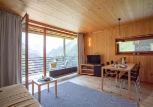 a living room with a table and a room with a view at Lechblick Appartement in Warth am Arlberg