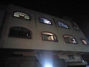 a building with six windows on it at night at Shree Yatri Niwas in Kolhapur