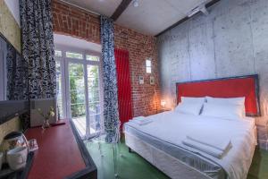 a bedroom with a large bed and a brick wall at Авторский Отель Бронзовый Кабан in Voronezh