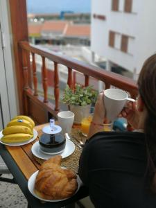 a woman sitting at a table with a cup of coffee and bread at Acogedora Vivienda Vacacional en Candelaria in Candelaria