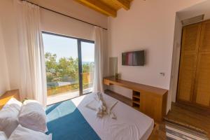 a bedroom with a bed and a large window at Alban Eco Hotel in Dhërmi +28 photos