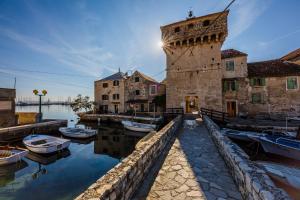 a building with boats in the water next to a tower at Water Castle House in Kaštela