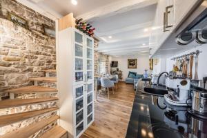 a kitchen and living room with a stone wall at Water Castle House in Kaštela