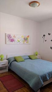 a bedroom with a bed with blue sheets and butterflies on the wall at Apartments Kolorček in Izola
