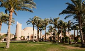 a mosque with palm trees in front of it at Shams Alam Beach Resort in Abū Ghuşūn
