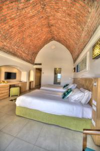 a bedroom with a large bed with a brick ceiling at Shams Alam Beach Resort in Abū Ghuşūn