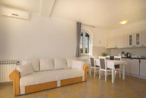 a living room with a couch and a table with chairs at Apartman Mendula in Premantura