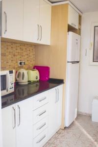 een keuken met witte kasten en een witte koelkast bij Villa MK in Kalkan
