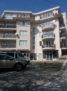 un edificio con coches estacionados frente a él en Апартамент "Амира" en Balchik