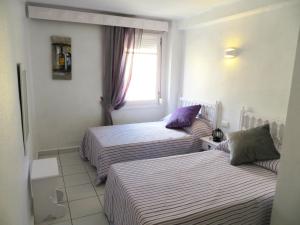 ハベアにある2 bedroom apartment L'Ancora in the Arenal Beachのベッド2台と窓が備わるホテルルームです。