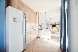 una cucina con mobili in legno e un frigorifero bianco di La Balconada de Toledo - PARKING GRATIS - 2 HABITACIONES a Toledo