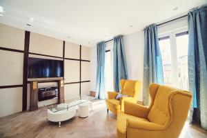 uma sala de estar com duas cadeiras amarelas e uma televisão em La Balconada de Toledo - PARKING GRATIS - 2 HABITACIONES em Toledo