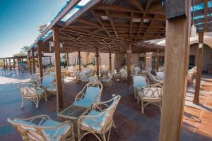a group of chairs and tables on a patio at Shams Alam Beach Resort in Abū Ghuşūn