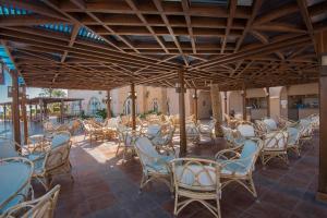 a restaurant with chairs and tables and a pool at Shams Alam Beach Resort in Abū Ghuşūn