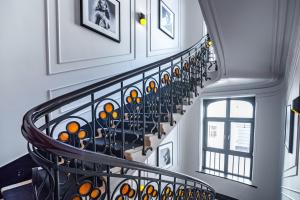a staircase with a wrought iron railing with paintings at Grand Hotel Roxolana in Ivano-Frankivsʼk