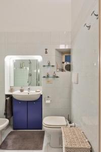 a white bathroom with a sink and a toilet at Arsenale Art Apartment in Turin