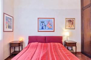 a bedroom with a bed with a red blanket and two tables at Arsenale Art Apartment in Turin