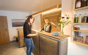 two women standing at a counter in a kitchen at Bussjägerhof in Böbing