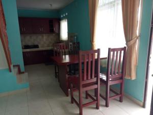 a kitchen with a wooden table and two chairs at GIISCA FAMILY VILLA in Pacet
