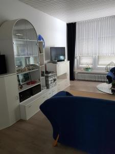 uma sala de estar com um armário branco e uma televisão em Ferienhaus Alte Straße em Bad Zwischenahn