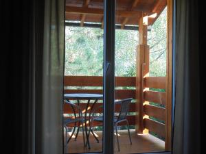 una ventana con vistas a una mesa y sillas en penzion BABÍ VRCH en Frýdlant nad Ostravicí