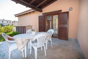 a white table and chairs on a patio at Villino Grosseto in San Teodoro