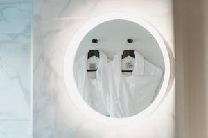 a round mirror in a bathroom with white towels at The Bonnie Badger in Gullane