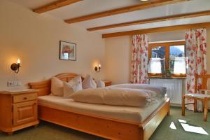 a bedroom with a large bed with a wooden frame at Ferienwohnungen Vogler in Oberstdorf