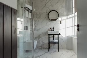 a bathroom with a shower and a sink and a mirror at The Bonnie Badger in Gullane