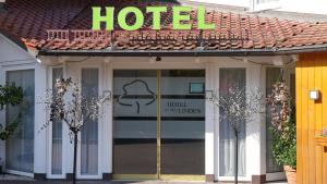 a hotel entrance with a sign on top of it at Hotel zu den Linden in Aschheim